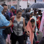 
              A group of migrants walk in the rain as they leave the city of Tapachula in Chiapas state, Mexico, early Monday, June 6, 2022. Several thousand migrants set out walking in the rain early Monday in southern Mexico, tired of waiting to normalize their status in a region with little work still far from their ultimate goal of reaching the United States. (AP Photo/Isabel Mateos)
            