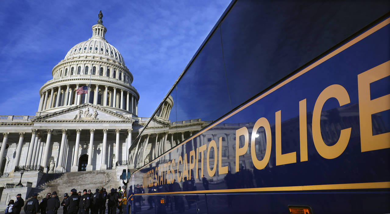 FILE - A large group of police arrive on a bus at the Capitol, Thursday, Jan. 6, 2022, in Washingto...