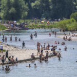 
              Bathers cool off at and in the Isar River, which flows through the middle of the Bavarian capital of  Munich, Germany, Sunday, June 19, 2022.  (Peter Kneffel/dpa via AP)
            