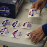 
              A pole worker lays out "I Voted" stickers at a polling place Tuesday, June 14, 2022, in Las Vegas. (AP Photo/John Locher)
            