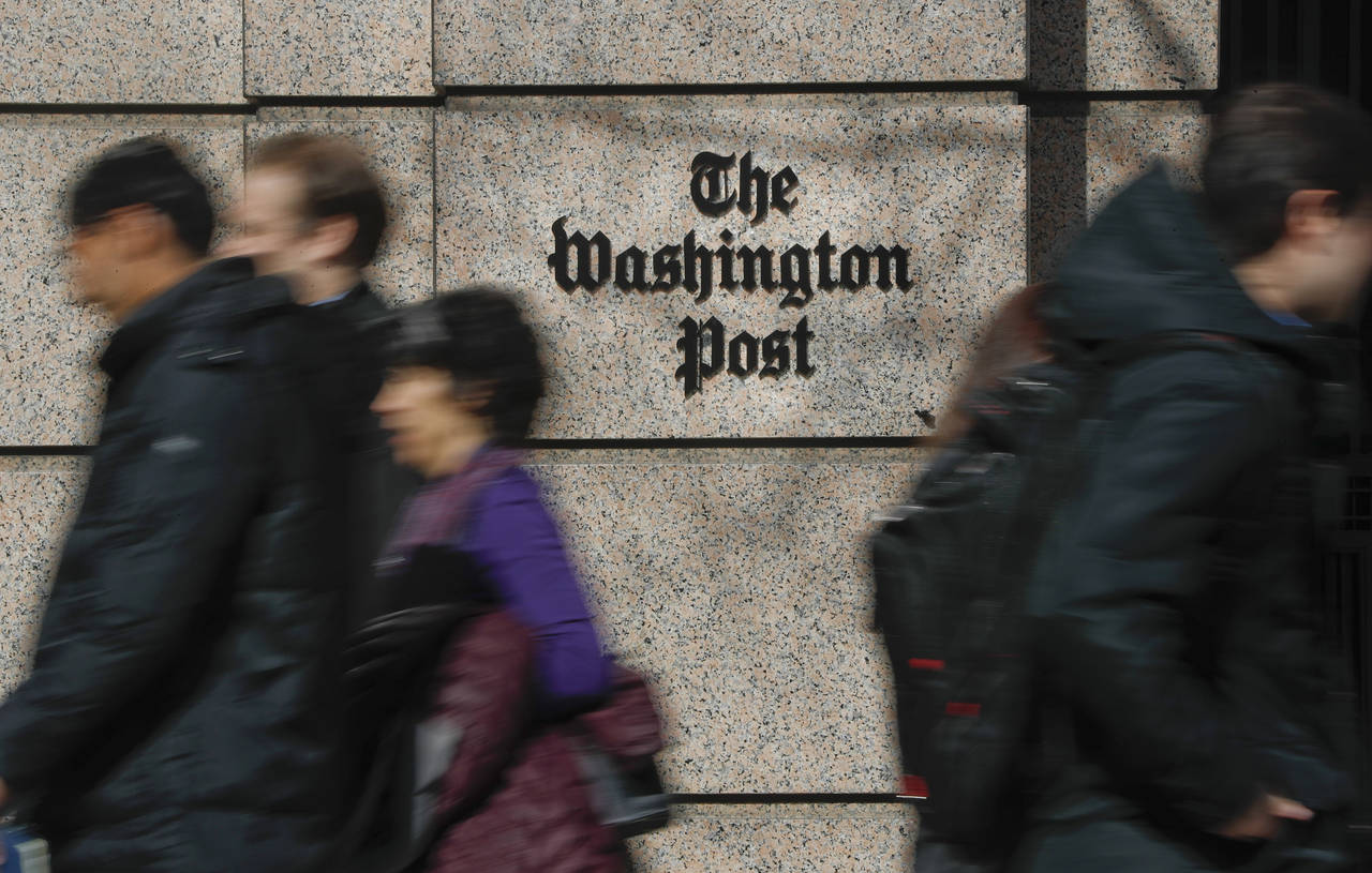 FILE - People walk by the One Franklin Square Building, home of The Washington Post newspaper, in d...