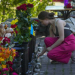 
              A woman lights a candle at a shopping center, after a rocket attack in Kremenchuk, Ukraine, Tuesday, June 28, 2022. (AP Photo/Efrem Lukatsky)
            