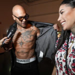 
              Marcell Jacobs, centre, and Nicole Daza, right, backstage being interviewed after the Dsquared2 men's Spring Summer 2023 collection presented in Milan, Italy, Friday, June 17, 2022. (AP Photo/Luca Bruno)
            