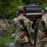 
              Ukrainian servicemen carry the coffin with the remains of Army Col. Oleksander Makhachek during his funeral in Zhytomyr, Ukraine, Friday, June 3, 2022. According to combat comrades Makhachek was killed fighting Russian forces when a shell landed in his position on May 30. (AP Photo/Natacha Pisarenko)
            