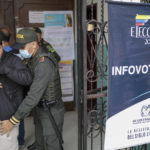 
              Police frisks a voter at the entrance of a polling station during a presidential runoff in Bucaramanga, Colombia, Sunday, June 19, 2022. (AP Photo/Ivan Valencia)
            