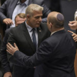 
              Israeli Prime Minister Naftali Bennett, right, and Foreign Minister Yair Lapid after a the vote on a bill to dissolve the parliament, at the Knesset, Israel's parliament, in Jerusalem, Thursday, June 30, 2022. Israel's parliament has voted to dissolve itself, sending the country to the polls for the fifth time in less than four years. (AP Photo/Ariel Schalit)
            