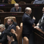 
              Israeli Prime Minister Naftali Bennett, center, speaks with lawmaker Mansour Abbas ahead of the vote on a bill to dissolve parliament, at the Knesset, Israel's parliament, in Jerusalem, Thursday, June 30, 2022. (AP Photo/Ariel Schalit)
            
