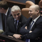 
              Israeli Prime Minister Naftali Bennett, right, and Foreign Minister Yair Lapid smile ahead of the vote on a bill to dissolve parliament, at the Knesset, Israel's parliament, in Jerusalem, Thursday, June 30, 2022. (AP Photo/Ariel Schalit)
            