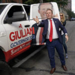 
              Republican gubernatorial candidate Andrew Giuliani throws car keys to an aide as he arrives to his polling place in a truck with his likeness on the side in New York, Tuesday, June 28, 2022. New Yorkers are casting votes in a governor's race that for the first time in a decade does not include the name "Cuomo" at the top of the ticket. The most prominent name for Democrats is Kathy Hochul while GOP candidates include Giuliani, the son of New York's former mayor. (AP Photo/Seth Wenig)
            
