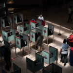 
              Election workers help as people vote at a polling place Tuesday, June 14, 2022, in Las Vegas. (AP Photo/John Locher)
            