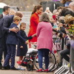 
              Britain's Kate, Duchess of Cambridge, Prince William, Prince George and Princess Charlotte peak to wellwishers during their visit to Cardiff Castle to meet performers and crew involved in the special Platinum Jubilee Celebration Concert taking place in the castle grounds later in the afternoon, Saturday June 4, 2022, on the third of four days of celebrations to mark the Platinum Jubilee. The events over a long holiday weekend in the U.K. are meant to celebrate the monarch’s 70 years of service. (Ben Birchall/PA via AP)
            