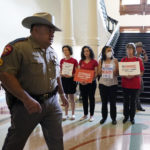 
              Women with Moms Demand Action gather outside the Texas Senate Chamber as the second day of a state Senate hearing begins, Wednesday, June 22, 2022, in Austin, Texas. The hearing is in response to the recent school shooting in Uvalde, Texas, where two teachers and 19 students were killed. (AP Photo/Eric Gay)
            
