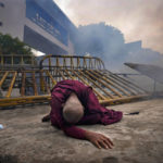 
              FILE- A Buddhist nun falls next to a barricade after inhaling tear gas during a protest against the economic crisis, outside police headquarters in Colombo, Sri Lanka, June 9, 2022. Lebanon and Sri Lanka may be a world apart, but they share a history of political turmoil and violence that led to the collapse of once-prosperous economies bedeviled by corruption, patronage, nepotism and incompetence. (AP Photo/Eranga Jayawardena, File)
            