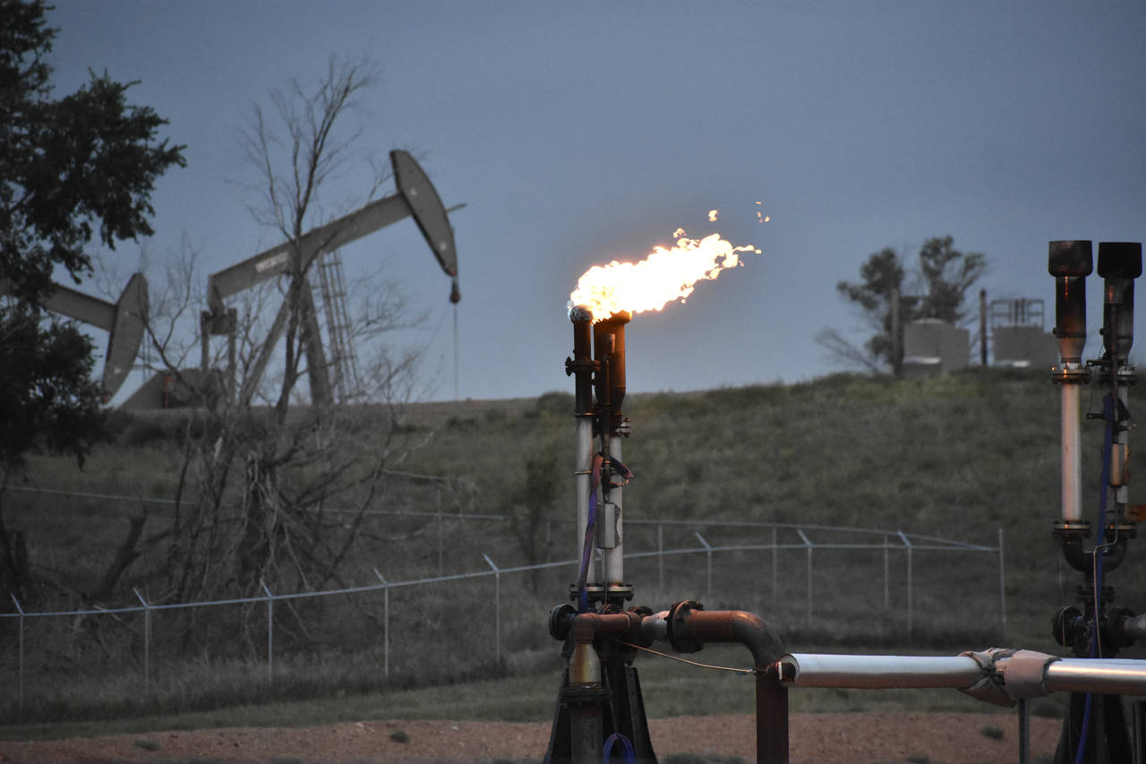 FILE - A flare to burn methane from oil production is seen on a well pad near Watford City, N.D., o...