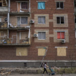 
              A woman pushes a baby stroller near a building damaged during a Russian attack in Slovyansk, eastern Ukraine, Saturday, June 4, 2022. (AP Photo/Bernat Armangue)
            