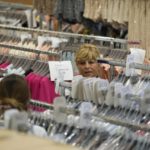 
              Nadia Zanola, chairman of the 'Cose di Maglia' factory, goes through racks of clothing at a warehouse section of unsold clothes, in Brescia, Italy, Tuesday, June 14, 2022. Small Italian fashion producers are still allowed to export to Russia, despite sanctions, as long as the wholesale price is under 300 euros. But they are having a hard time getting paid, due to restrictions tied to the financial sector. (AP Photo/Luca Bruno)
            
