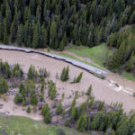 
              This aerial photo provided by the National Park Service shows a flooded out North Entrance Road, of Yellowstone National Park in Gardiner, Mont., on June 13, 2022. Flooding caused by heavy rains over the weekend caused road and bridge damage in Yellowstone National Park, leading park officials to close all the entrances through at least Wednesday. Gardiner, a town just north of the park, was isolated, with water covering the road north of the town and a mudslide blocking the road to the south. (Jacob W. Frank/National Park Service via AP)
            