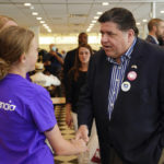 
              Gov. JB Pritzker greets Lillian Hannigan of Alton, IL after Pritzker signed legislation to assist Type 1 Diabetes patients like Hanningan at Manny's Deli in Chicago, Tuesday, June 28, 2022.  Illinois Republicans on Tuesday will choose a nominee to take on  Pritzker, a billionaire who has spent millions trying to get the rival he wants and increase his already sizable advantage in the state this fall. (Kevin Tanaka /Chicago Sun-Times via AP)
            