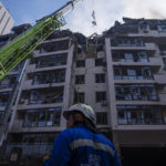 
              Firefighters work at the scene at a residential building following explosions, in Kyiv, Ukraine, Sunday, June 26, 2022. Several explosions rocked the west of the Ukrainian capital in the early hours of Sunday morning, with at least two residential buildings struck, according to Kyiv mayor Vitali Klitschko. (AP Photo/Nariman El-Mofty)
            