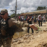 
              A federal police officer stands guard as a suspect is transported to the area where Indigenous expert Bruno Pereira and freelance British journalist Dom Phillips disappeared, in Atalaia do Norte, Amazonas state, Brazil, Wednesday, June 15, 2022. Federal police said in a statement Tuesday night that they had arrested a second suspect in connection with the disappearance of Phillips and Pereira in a remote area of the Amazon. (AP Photo/Edmar Barros)
            