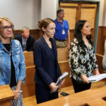 
              Sheena Greitens, center, the ex-wife of former Missouri Gov. and U.S. Senate candidate Eric Greitens, rises at the beginning of a court session in a child custody case on Thursday, June 23, 2022, at the Boone County Courthouse in Columbia, Mo. An attorney for Sheena Greitens said her client had received threats after a Senate campaign ad for Eric Greitens depicted him with a gun hunting "RINOs," or Republicans in Name Only. (AP Photo/David A. Lieb)
            