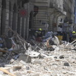 
              Firemen work in the rubble of a five-storey building after a facade wall and roofing elements fell onto the street and parked cars in the centre of Budapest, Hungary, Monday, June 27, 2022. Several people were injured, many cars were damaged and five vehicles were completely flattened. There were no casualties. (Zoltan Mihadak/MTI via AP)
            