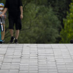 
              A boy wearing a face mask rides a scooter at a public park in Beijing, Tuesday, June 28, 2022. (AP Photo/Mark Schiefelbein)
            