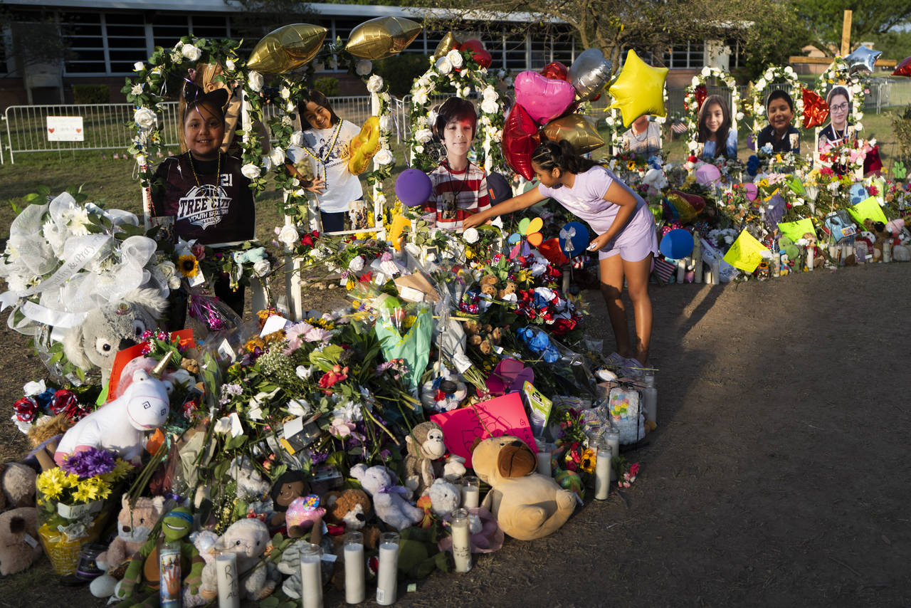 Aaliyah Banda, 11, places a bracelet in front of Uziyah Garcia's photo, one of the victims killed i...