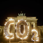 
              FILE - Activists of the environment organization Greenpeace protest with CO2 letters illuminated with flames in front of the Brandenburg Gate against the climate change in Berlin, Germany, May 6, 2021. Two new high-powered panels have started to look at the ethics and governing rules surrounding the controversial technologies of geoengineering. They are looking at the idea of putting particles in the air to reflect sunlight, brightening clouds and sucking carbon dioxide out of the atmosphere. (AP Photo/Markus Schreiber, File)
            