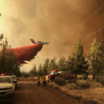 
              FILE - This photo provided by the Oregon Department of Forestry shows a firefighting tanker making a retardant drop over the Grandview Fire near Sisters, Ore., Sunday, July 11, 2021. The wildfire doubled in size to 6.2 square miles (16 square kilometers) Monday, forcing evacuations in the area, while the state's biggest fire continued to burn out of control, with containment not expected until November. (Oregon Department of Forestry via AP, File)
            