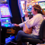 
              FILE - A woman smokes while playing a slot machine at the Ocean Casino Resort on Feb. 10, 2022, in Atlantic City, N.J. A report issued Friday, June 17, 2022, by a Las Vegas gambling research company suggested that ending smoking in casinos will not result in significant financial harm to the businesses. (AP Photo/Wayne Parry, File)
            