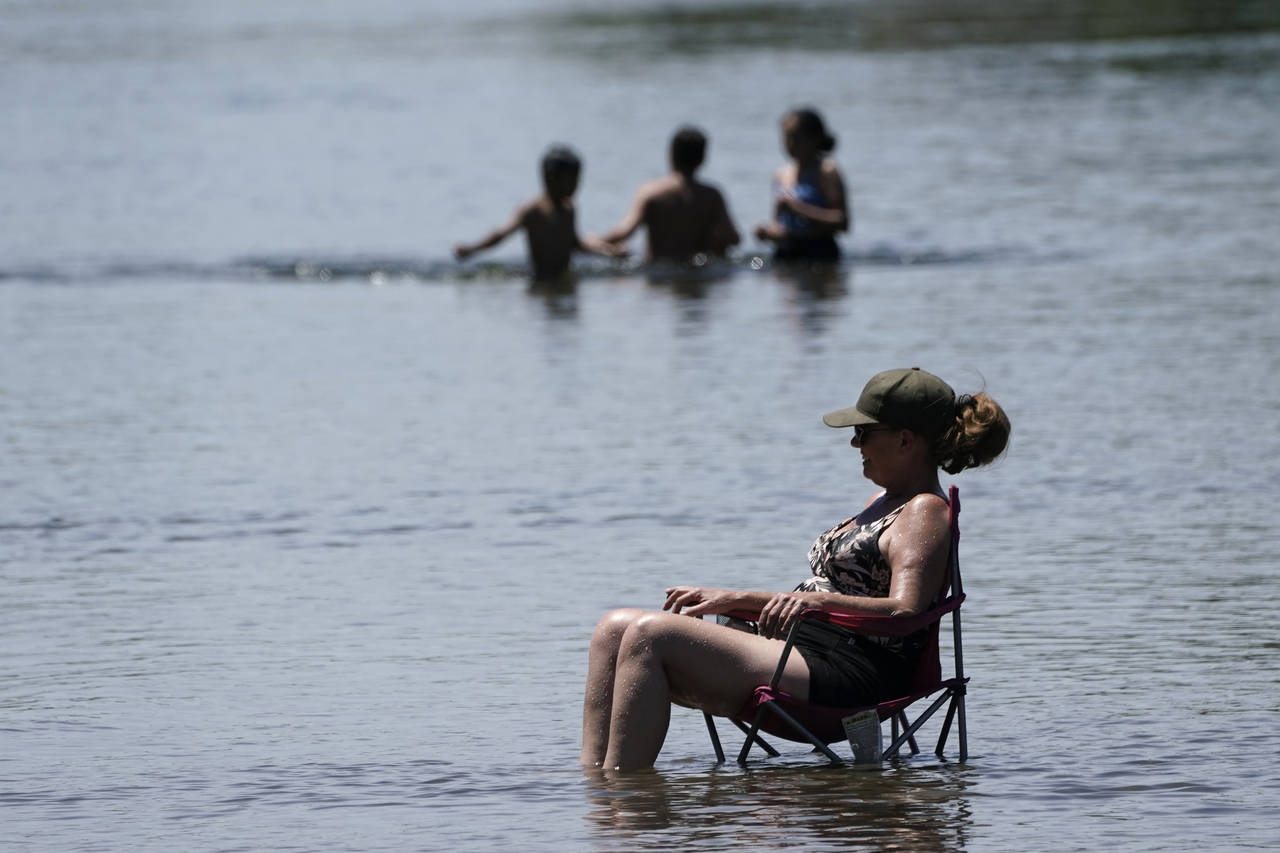 Dianna Andaya, relaxes in the cooling water of the American River as the temperature climbed over t...
