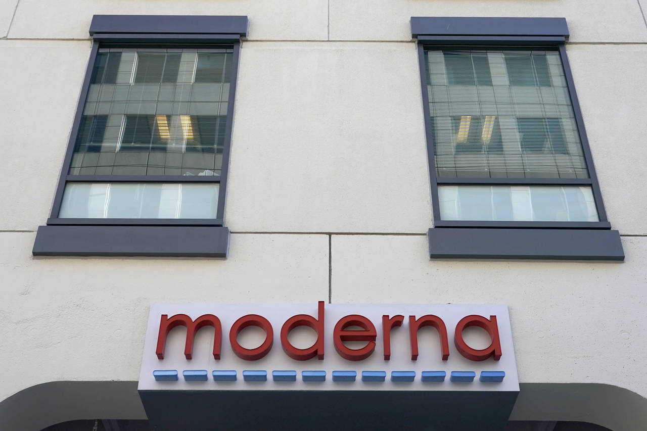 FILE - In this Dec. 15, 2020, file photo, a sign for Moderna, Inc. hangs on its headquarters in Cam...
