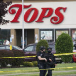 
              FILE - Police secure an area around a supermarket where several people were killed in a shooting, Saturday, May 14, 2022, in Buffalo, N.Y.  New York’s new law barring sales of bullet-resistant vests to most civilians doesn't cover the type of armor worn by the gunman who killed 10 people at the Buffalo supermarket, a gap that could limit its effectiveness in deterring future military-style assaults. (Derek Gee/The Buffalo News via AP, File)
            