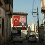 
              FILE - A portrait of Turkish President Recep Tayip Erdogan and Turkish flags are seen on a building in the Turkish occupied area at the Turkish Cypriot breakaway north part of divided capital Nicosia, Cyprus, Wednesday, March 10, 2021. The president of ethnically divided Cyprus says he will lodge a complaint with the United Nations over Turkey’s new financial assistance deal with breakaway Turkish Cypriots. (AP Photo/Nedim Enginsoy, File)
            
