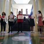 
              Women with Moms Demand Action gather outside the Texas Senate Chamber as the second day of a hearing begins, Wednesday, June 22, 2022, in Austin, Texas. The hearing is in response to the recent school shooting in Uvalde, Texas, where two teachers and 19 students were killed. (AP Photo/Eric Gay)
            