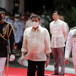
              Outgoing Philippines president Rodrigo Duterte, center, is escorted as he reviews an honor guard as incoming President Ferdinand Marcos Jr., second right, looks on during his inauguration ceremony at the Malacanang Presidential Palace grounds in Manila, Philippines, Thursday, June 30, 2022. Marcos, the son of the late president Ferdinand Marcos has been sworn in as the Philippine president. (Francis R. Malasig/Pool Photo via AP)
            