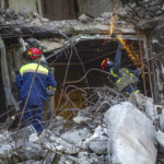 
              Ukrainian emergency service personnel work outside the damaged building following shelling, in Kharkiv, Ukraine, Saturday, June 4, 2022. (AP Photo/Sofiia Bobok)
            