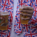 
              A Royal fan holds two pints of lager on the Mall near Buckingham Palace, London, Saturday June 4, 2022 ahead of the Platinum Jubilee concert, on the third of four days of celebrations to mark the Platinum Jubilee. The events over a long holiday weekend in the U.K. are meant to celebrate Queen Elizabeth II's 70 years of service. (AP Photo/Frank Augstein)
            