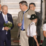 
              President Joe Biden, left, holds a bouquet that was given to him by children as he is accompanied by Bavarian Prime Minister Markus Soeder after arriving at Franz-Josef-Strauss Airport near Munich, Germany Saturday, June 25, 2022, ahead of the G7 summit. The G7 Summit will take place at Castle Elmau near Garmisch-Partenkirchen from June 26 through June 28, 2022. (AP Photo/Markus Schreiber)
            