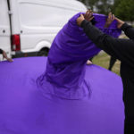 
              A member of the Mahogany carnival group receives help to put on her costume before taking part in a rehearsal for their upcoming performance at the Platinum Jubilee Pageant, at Queens Park Community School, in north London, Saturday, May 28, 2022. (AP Photo/Matt Dunham)
            