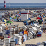 
              People enjoy the beach, near to the Baltic Sea in Warnemunde, Germany, Saturday, June 18, 2022. (Jens Buttner/dpa via AP)
            