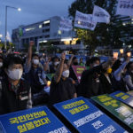 
              Members of the Public Service and Transport Workers Union stage a rally to support the ongoing trucker strike outside the presidential office in Seoul, South Korea, Tuesday, June 14, 2022. South Korea's prime minister warned Tuesday that the disruption of cargo transport could cause "irrecoverable" damages on the country's economy, as a nationwide truckers' strike entered its eighth day. The signs read "We support for the ongoing trucker strike." (AP Photo/Ahn Young-joon)
            
