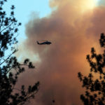
              A helicopter drops water on the mountainside as the Rices Fire burns near French Corral, Calif., on Tuesday, June 28, 2022. (Carlos Avila Gonzalez/San Francisco Chronicle via AP)
            
