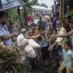 
              A Bangladeshi army soldier distributes relief material to flood affected people in Sylhet, Bangladesh, Wednesday, June 22, 2022. (AP Photo/Mahmud Hossain Opu)
            