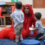 
              A drag queen who goes by the name Flame reads stories to children and their caretakers during a Drag Story Hour at a public library in New York, Friday, June 17, 2022. (AP Photo/Seth Wenig)
            