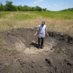
              Farmer Serhiy, a local grain producer, shows a crater left by a Russian shell on his field in the village of Ptyche in eastern Donetsk region, Ukraine, Sunday, June 12, 2022. Serhiy claims he cannot sell his grains because nobody wants to come to the area which has been under Russian shelling. Ukraine is one of the world’s largest exporters of wheat and corn but Russia's invasion and a blockade of its ports have halted much of that flow. (AP Photo/Efrem Lukatsky)
            