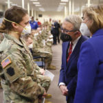 
              FILE - Ohio Gov. Mike DeWine, center, and his wife Fran, right, talk with specialist Emily Milosevic as they tour the Defense Supply Center Columbus in Columbus, Ohio, as members of the Ohio Army National Guard prepare to deploy to aid Ohio hospitals during the current surge in COVID-19 hospitalizations Jan. 6, 2022. Up to 40,000 Army National Guard soldiers across the country - or about 13% of the force — have not yet gotten the mandated COVID-19 vaccine, and as the deadline for shots looms, at least 14,000 of them have flatly refused and could be forced out of the service. (AP Photo/Paul Vernon, File)
            