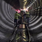 
              FILE - Tunnel workers push equipment up a rail track to a machine boring a 2.5-mile bypass tunnel for the Delaware Aqueduct in Marlboro, N.Y., on May 16, 2018. A long-planned temporary shutdown of a leaking aqueduct that supplies about half of New York City's drinking water will be pushed back a year, giving officials more time to prepare for the months-long closure. (AP Photo/Julie Jacobson, File)
            