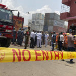 
              Military personnel and officials stand at the BM Inland Container Depot, where a fire broke out around midnight Saturday in Chittagong, about 210 kilometers (130 miles) southeast of, Dhaka, Bangladesh, Monday, June 6, 2022. Dozens of people were killed and more than 100 others were injured after the inferno broke out following explosions in a container full of chemicals. (AP Photo/ Al-emrun Garjon)
            
